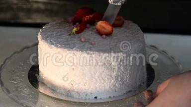 糕点厨师切蛋糕。 草莓酸奶蛋糕。 由奶油海绵蛋糕组成，上面覆盖着以奶油为基础的活